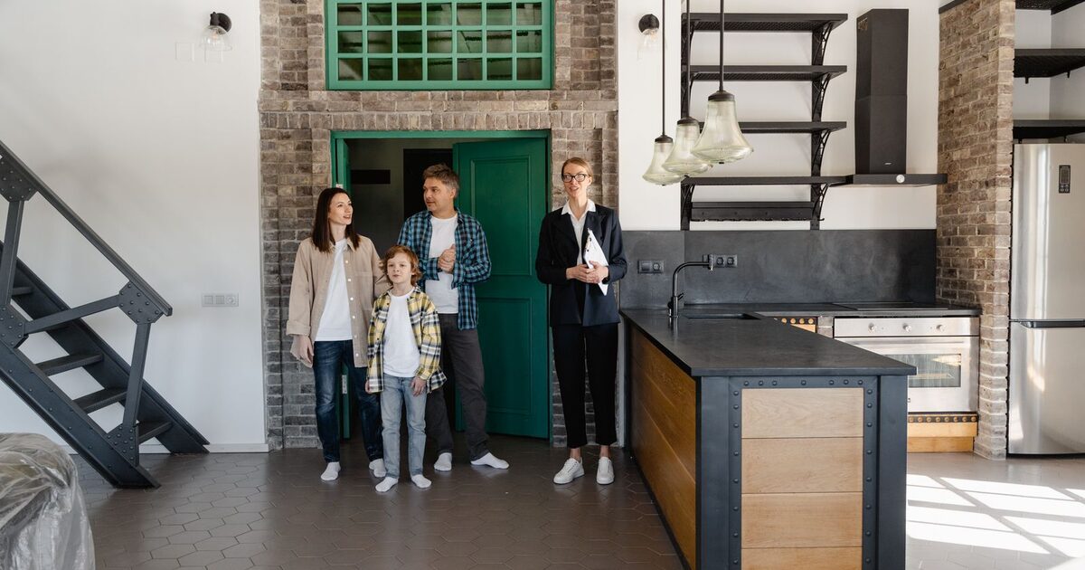 A family touring the interior of a home they are considering buying